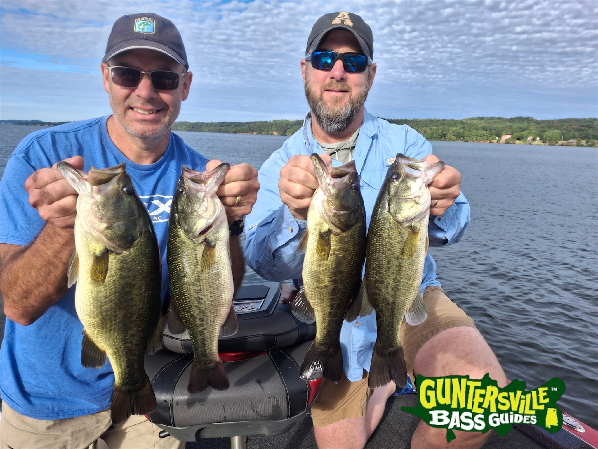 Capt. Phillip clients holding four Lake Guntersville bass during an October guided fishing trip
